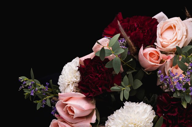 Gros plan d'un luxueux bouquet de roses roses et blancs, dahlias rouges
