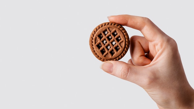 gros plan la main avec biscuit au chocolat