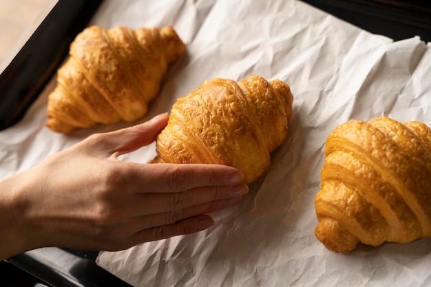 Photo gratuite gros plan main et croissants