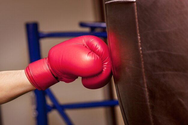 Gros plan de la main du boxeur au moment de l'impact sur le sac de boxe