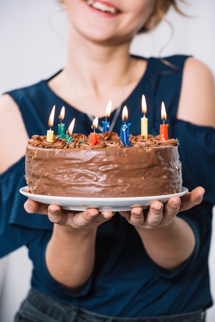 Gros plan, de, main fille, tenue, plaque, de, gâteau chocolat, à, allumé, bougies