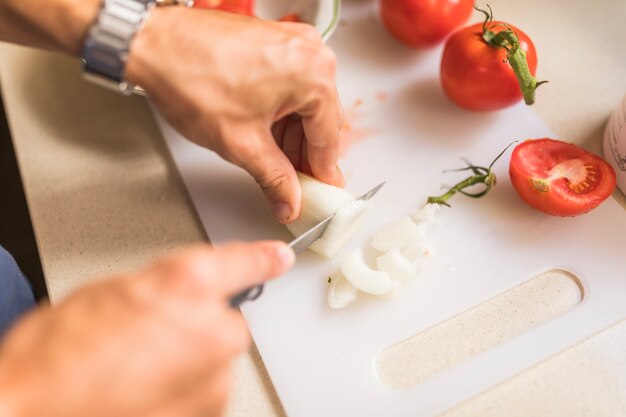 Gros plan, de, main homme, couper, radis blanc, à, couteau, sur, planche à découper