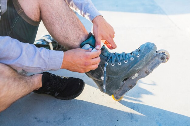 Gros plan, de, a, main homme, mettre, sur, patin à roulettes