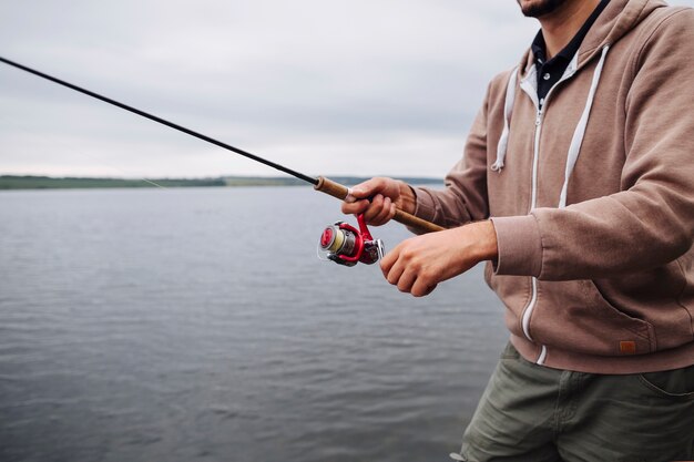 Gros plan, de, main homme, tenue, canne à pêche, près, les, lac