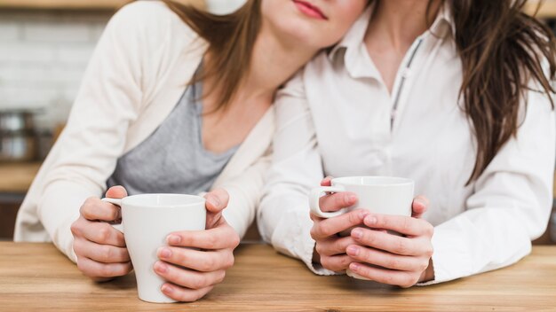 Gros plan, de, main lesbienne, femme, tenue, tasse café, sur, table