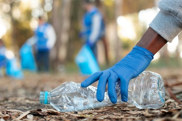 Gros plan main tenant une bouteille en plastique