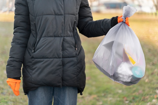 Gros plan main tenant un sac poubelle