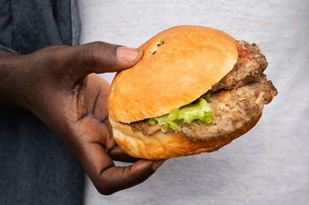 Gros plan main tenant savoureux burger