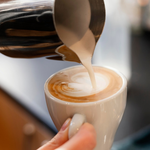 Gros plan main tenant une tasse de café