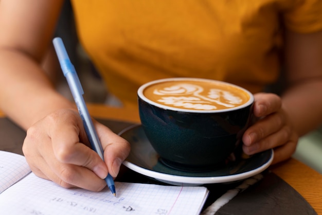 Gros plan main tenant une tasse de café