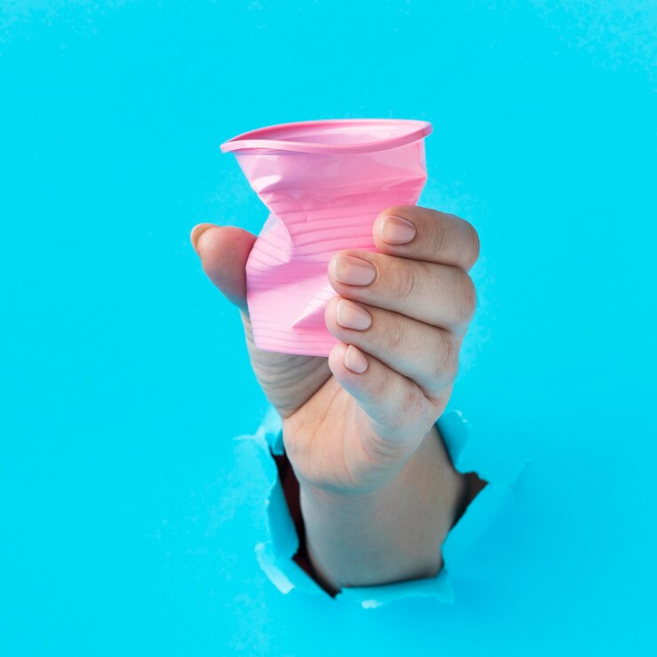 Photo gratuit gros plan main tenant une tasse en plastique