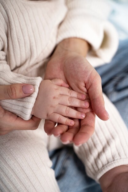 Gros plan sur les mains de bébé et les mains de la mère