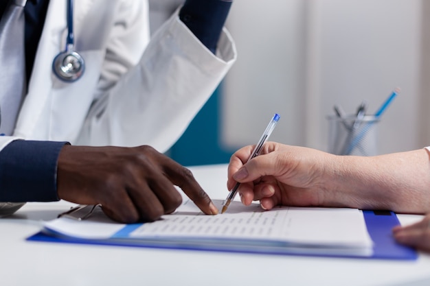 Photo gratuite gros plan des mains sur le bureau à la clinique de soins de santé