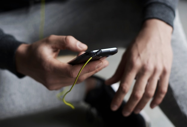 Gros plan sur les mains en choisissant une chanson sur le téléphone