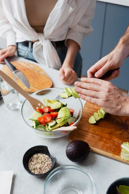 Gros plan sur les mains coupant des légumes