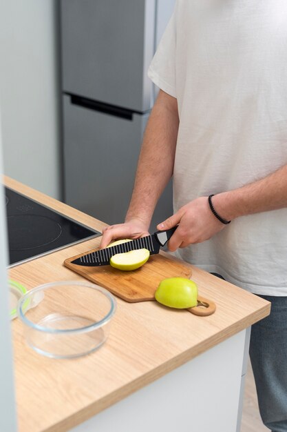 Gros plan des mains coupant la pomme avec un couteau