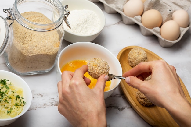 Gros plan des mains faisant des croquettes alimentaires