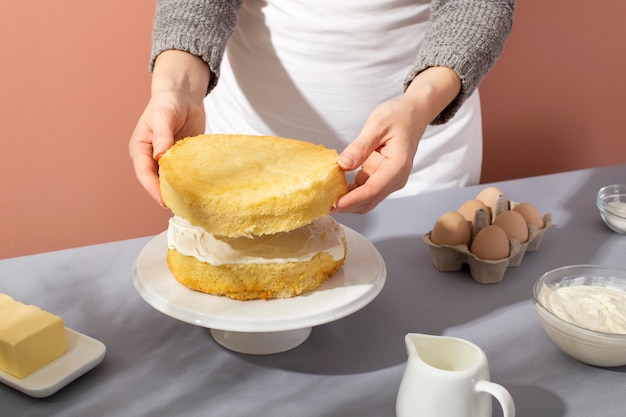 Photo gratuite gros plan des mains faisant un gâteau