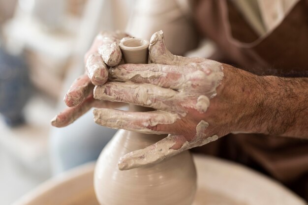 Gros plan sur les mains faisant de la poterie comme passe-temps