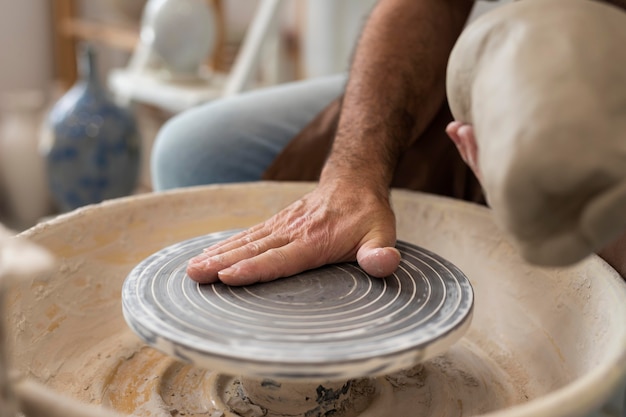 Photo gratuite gros plan des mains faisant de la poterie