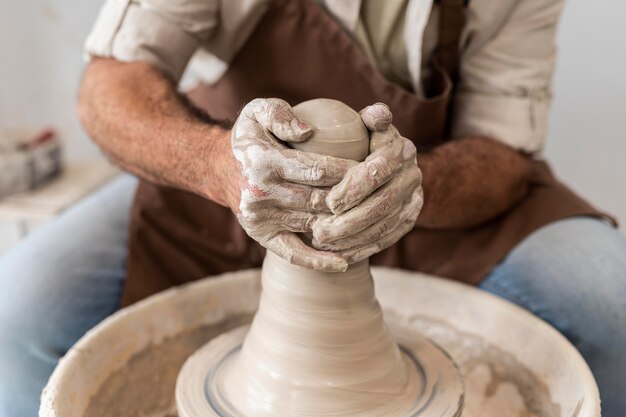 Gros plan des mains faisant de la poterie