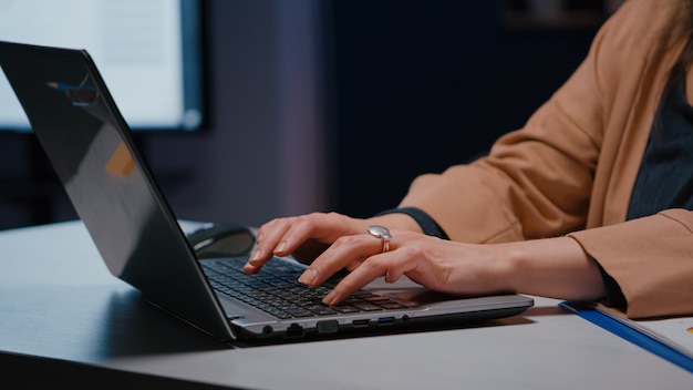 Gros plan sur les mains d'une femme d'affaires sur le clavier assis au bureau dans le bureau d'une entreprise de démarrage planifiant un projet économique sur internet. Directeur exécutif tapant des statistiques financières répondant à un courrier électronique professionnel