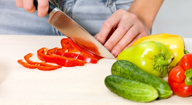 Gros plan des mains d'une femme cuisine salade dans la cuisine