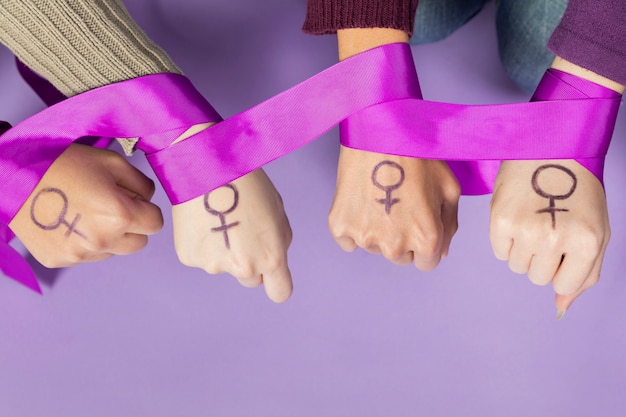 Gros plan des mains de femmes avec le symbole du féminisme