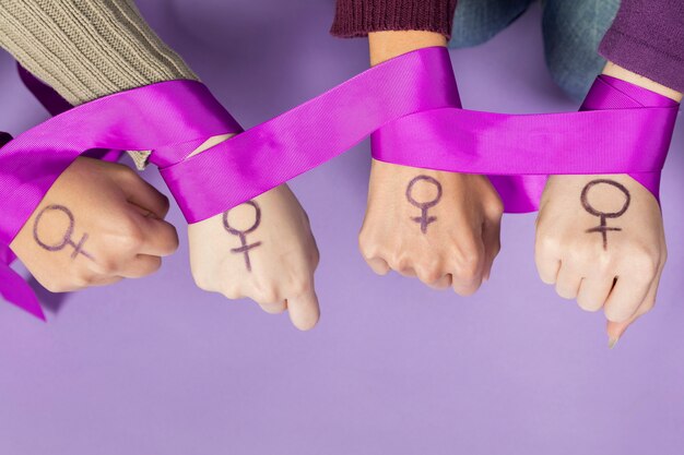 Gros plan des mains de femmes avec le symbole du féminisme