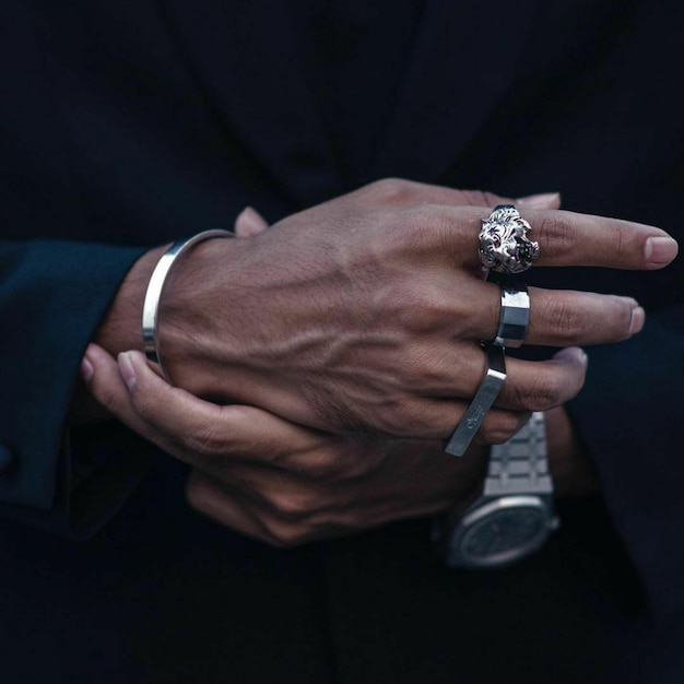 Photo gratuite gros plan des mains d'un homme d'affaires avec un anneau de tigre en argent orné et d'autres accessoires