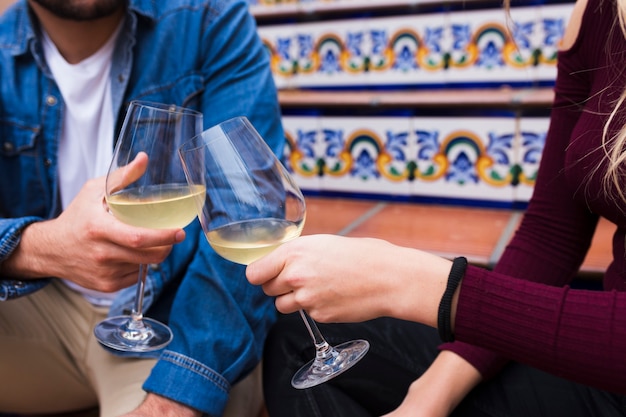 Photo gratuite gros plan des mains d'un jeune couple tinter les verres de vin