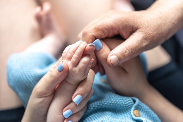 Gros plan sur les mains de la maman et de la grand-mère du bébé