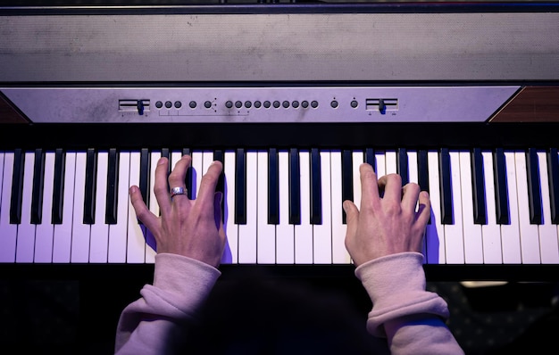 Gros plan des mains masculines jouant les touches du piano