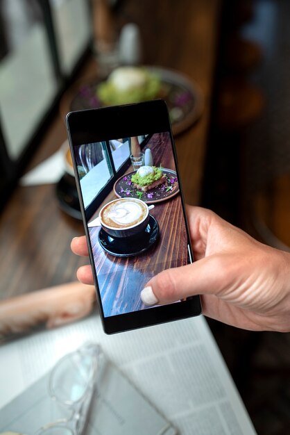 Gros plan des mains prenant de délicieuses photos de café