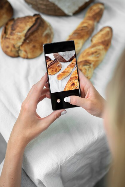 Gros plan des mains prenant des photos de produits de boulangerie