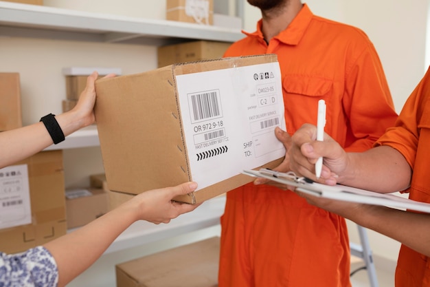 Gros plan sur les mains remettant les boîtes de livraison au courrier