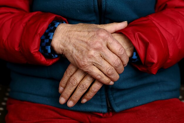 Gros plan des mains ridées d'une femme âgée