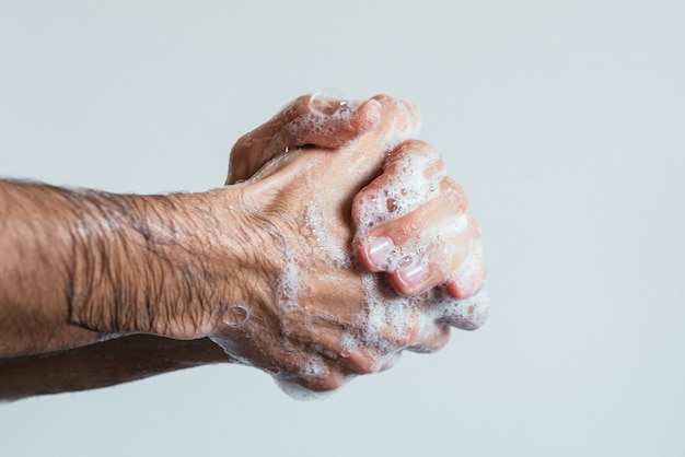 Gros plan des mains savonnées d'une personne