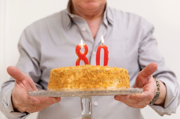 Gros plan des mains tenant une assiette à gâteau