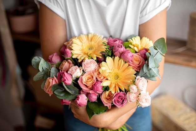 Gros plan des mains tenant un bouquet de fleurs