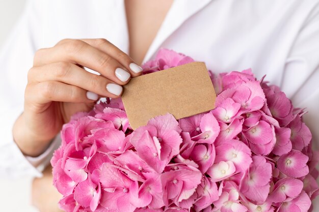 Gros plan des mains tenant un bouquet d'hortensias