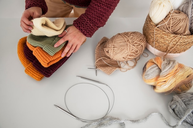 Gros plan des mains tenant des chapeaux tricotés