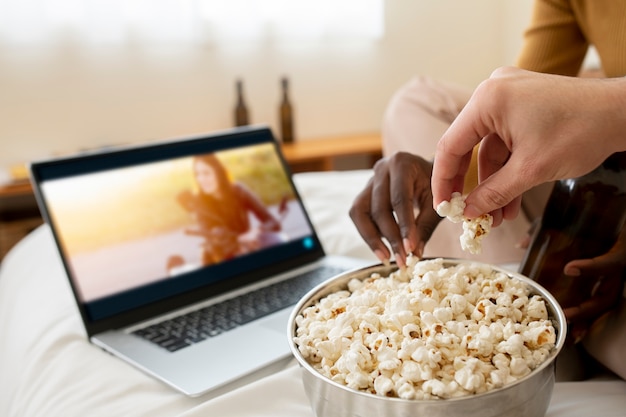 Gros plan des mains tenant du pop-corn