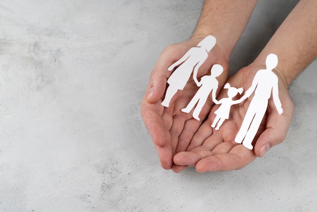 Gros plan sur les mains tenant la famille de papier