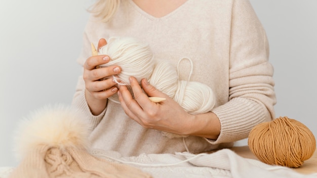 Gros plan mains tenant des fils à tricoter
