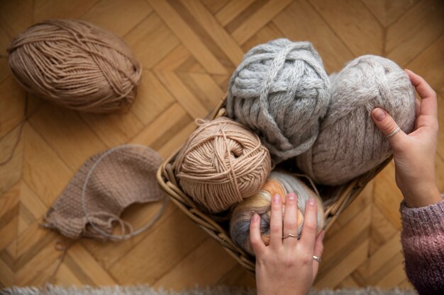 Gros plan des mains tenant des fils à tricoter