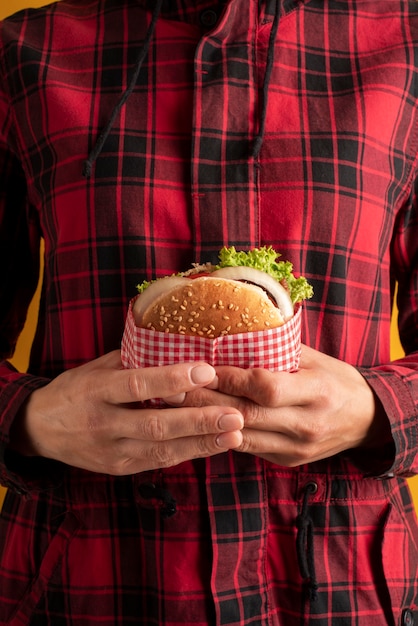 Photo gratuite gros plan des mains tenant un hamburger