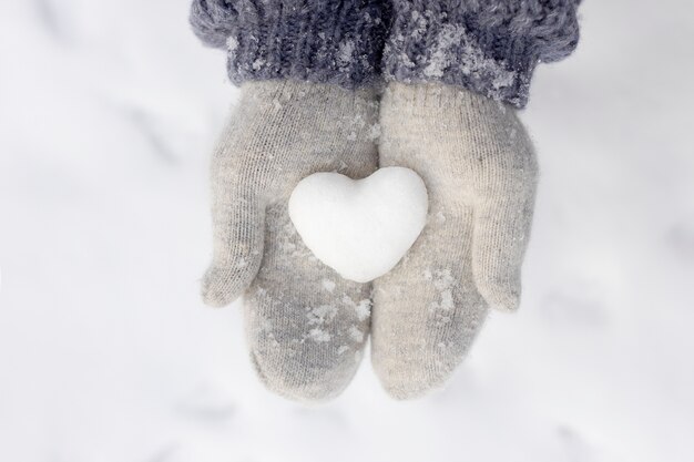 Gros plan des mains tenant de la neige