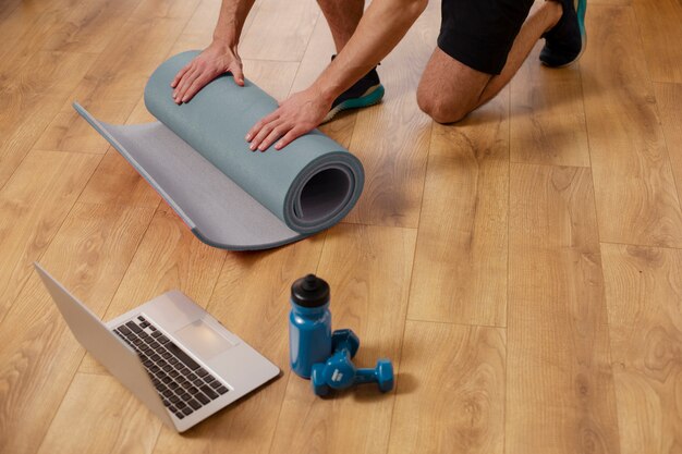 Gros plan des mains tenant un tapis de yoga