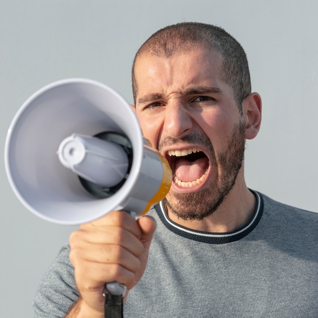 Photo gratuite gros plan d'une manifestante avec un mégaphone criant